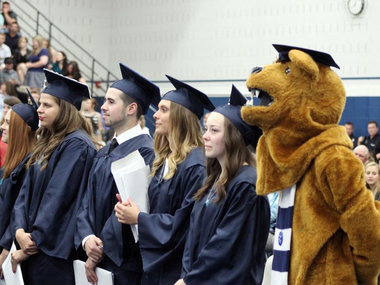 Students at Commencement stand at attention with Nittany Lion