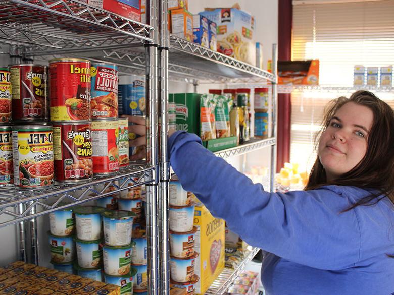 一位女学生在狮子食品储藏室帮忙储存食物