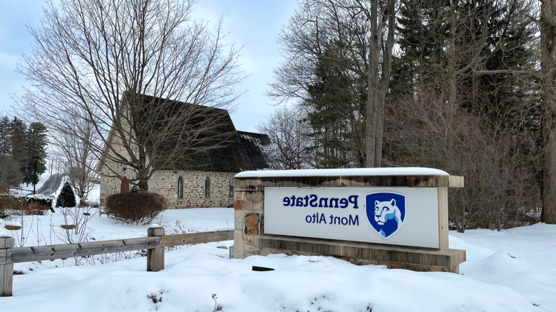 Wintry snow photo of the Emmanual Chapel and the campus sign. 