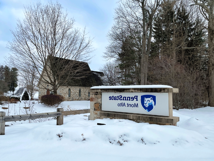 Wintry snow photo of the Emmanual Chapel and the campus sign. 